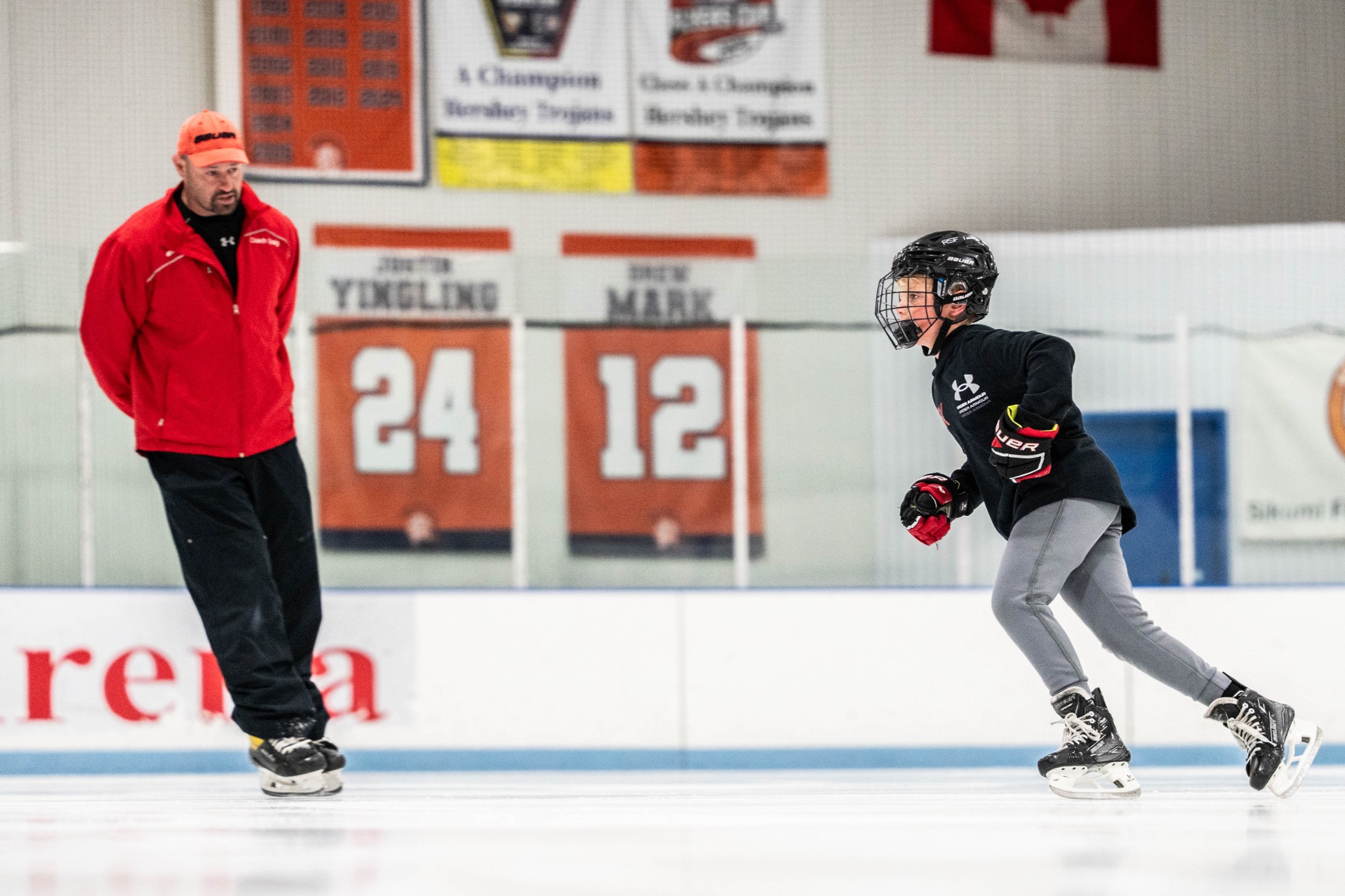 Craig coaching a hockey player on the ice